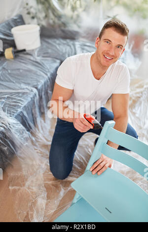 Handyman or craftsman assembles a chair when moving to the new house Stock Photo