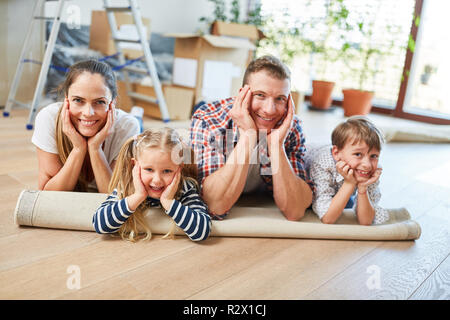Happy parents and two children are resting after moving to the new house Stock Photo