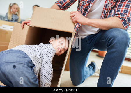 Boy and dad play with moving box when moving to their new home Stock Photo