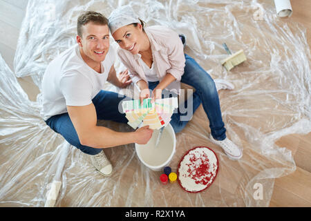 Happy young couple shows color samples for the design in the new house Stock Photo