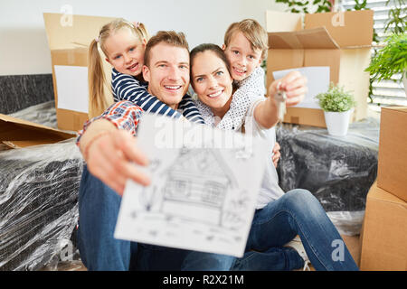 Happy family with picture of house as a sign for real estate and property Stock Photo