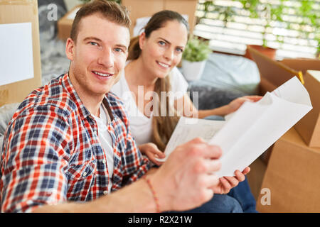 Young couple planning the new house together and studying architectural drawings Stock Photo