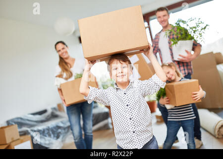 Boy carries a moving box when moving with the family in the new house Stock Photo