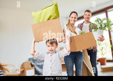 Little boy helps with the move and carries moving boxes in the new home Stock Photo
