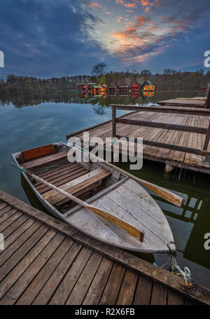 Tata, Hungary - Fishing boat by Lake Derito (Derito to) with wooden fishing cottages and beautiful sunset Stock Photo
