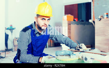 happy builder is preparing for repair in the room at object. Stock Photo