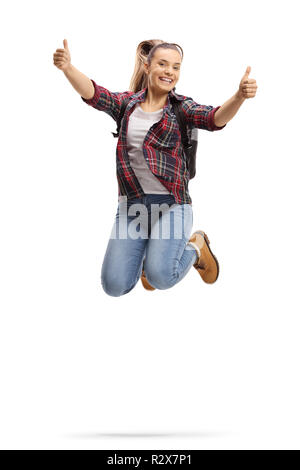 Full length shot of a female student jumping and showing thumbs up isolated on white background Stock Photo