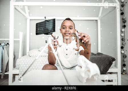 Joyful nice boy playing with toys of dinosaurs Stock Photo