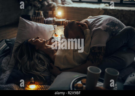 Young couple in love hugging and smiling on background of glowing lightbulbs. Stock Photo
