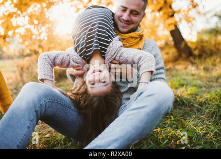 A young father having fun with a small daughter in autumn nature. Stock Photo