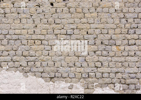 Old vintage grey brick wall with traces of white plaster Stock Photo
