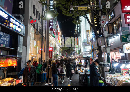 Streets of Myeongdong in Seoul, South Korea busy with shoppers and tourists at night.  Lights from shops and shop signs light up the street Stock Photo