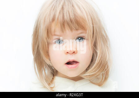 Close up portrait blond hair baby girl with a scratch on her nose isolated on the white background. Surprised female toddler, keeps mouth opened. Child safety concept, injuries from falling down. Stock Photo