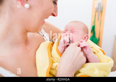 Close-up of mother carrying her baby Stock Photo