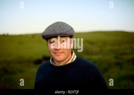 Portrait of a smiling mid-adult farmer wearing a tweed cap. Stock Photo