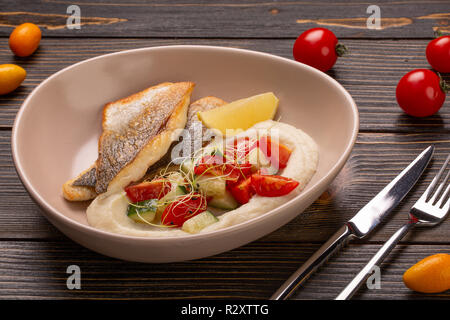 dish with fried fish cod, stewed potatoes with dill, pickled cucumber, limon and red pepper. Ukrainian food Stock Photo