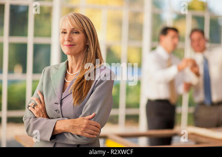 Mid adult businesswoman standing with her arms crossed. Stock Photo