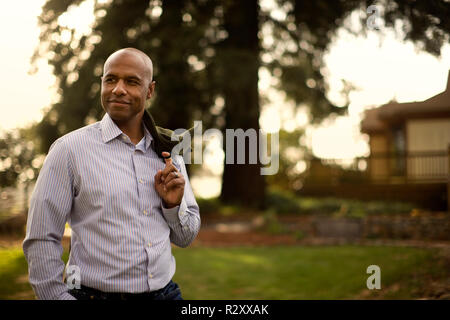 Smiling mid adult man standing in a park. Stock Photo