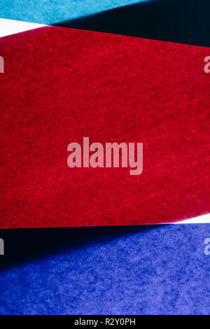 Overlapping pieces of multicolored construction paper on illuminated backdrop. Stock Photo