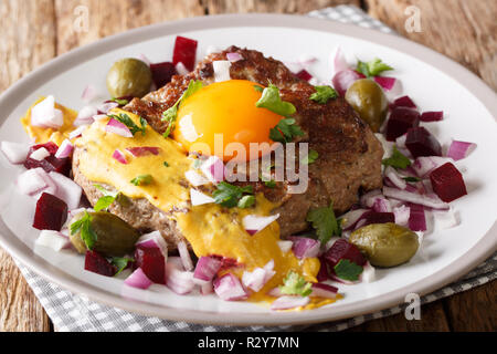 Freshly Cooked Danish Pariserbof Steak with egg, vegetables and mustard close-up on a plate on the table. Horizontal Stock Photo