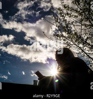 silhoette of figure with sun and clouds behind Stock Photo