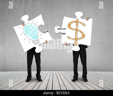 Holding puzzles with idea is money doodles on it Stock Photo