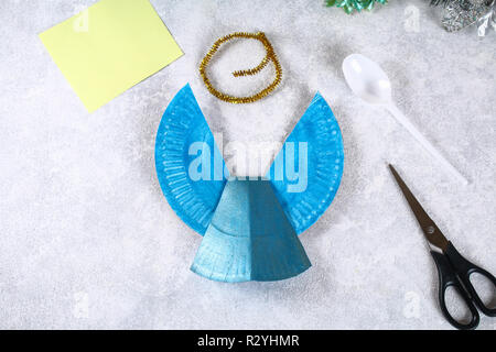 Creative hobby. DIY Christmas decoration. Process of making handmade  christmas paper angels Stock Photo