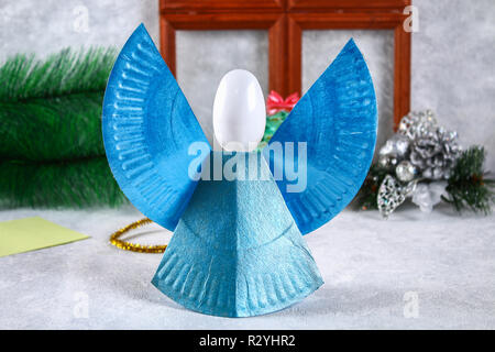 Creative hobby. DIY Christmas decoration. Process of making handmade  christmas paper angels Stock Photo