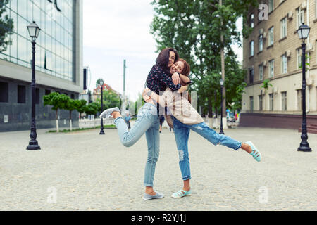 Portrait of carefree smiling sisters hugging and having fun together. Outdoor photo of lovely Caucasian young ladies spending weekend together. Stock Photo