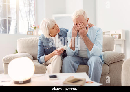 Grey-haired mature woman looking sick and tired Stock Photo