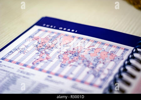 Spiral diary open on the page with the world map with time zones. Business and world travel Stock Photo