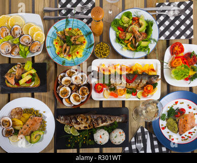 Top view of dishes from trout and mollusks served on wooden background Stock Photo
