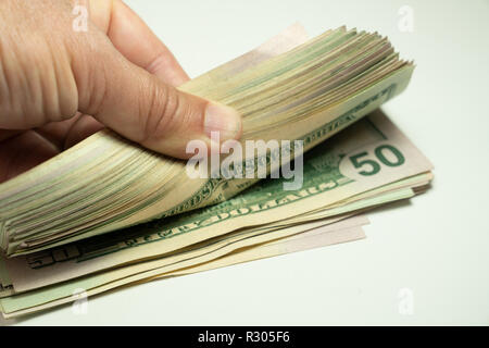 Cash dollars lying on the plane. Hand counting US Dollar bills or paying in cash. Stock Photo
