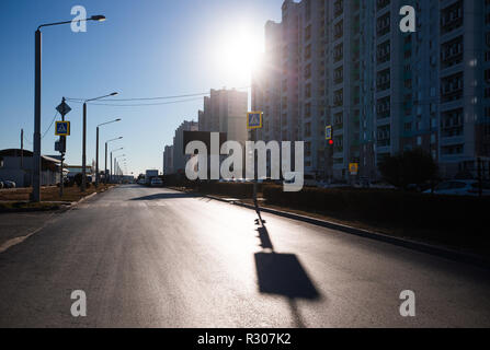 Sunny morning in the city, residential buildings and empty street.