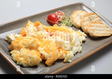 Scrambled eggs wioth some bread and cherry tomatoes Stock Photo