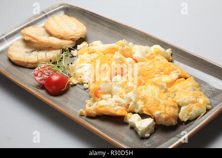 Scrambled eggs wioth some bread and cherry tomatoes Stock Photo