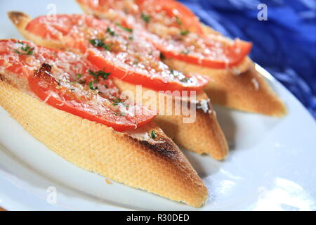 Sandwiches with tomatoes and melted cheese on top Stock Photo