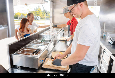 Young chefs in a food truck preparing food Stock Photo
