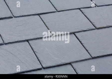 Closeup of traditional grey slate roof tiles on a pitched roof Stock Photo