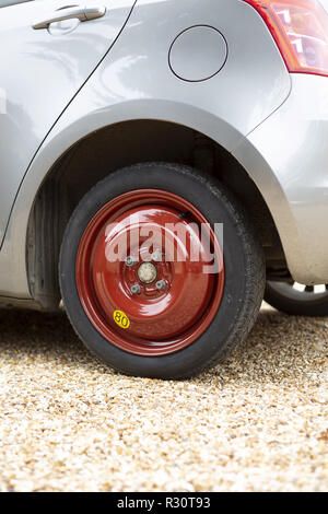 Small car fitted with a spare tyre or tire on a space saver wheel Stock Photo