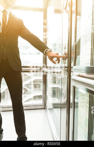 Man pressing elevator button. finger presses elevator button. businessman in lift Stock Photo