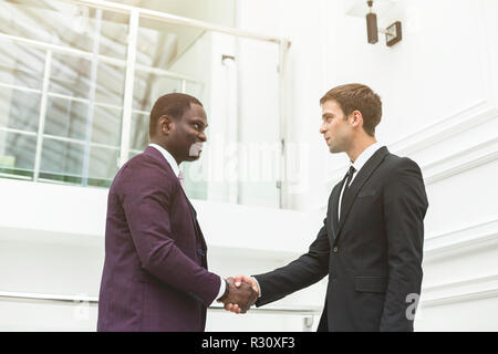 two young businessmen shake hands Stock Photo