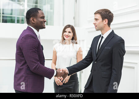 two young businessmen shake hands Stock Photo