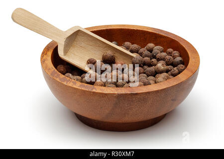 Allspice berries in wooden bowl with scoop Stock Photo