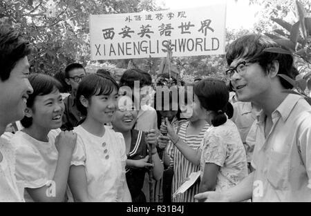 (181121) -- BEIJING, Nov. 21, 2018 (Xinhua) -- File photo taken in 1985 shows people practicing English in Xi'an, northwest China's Shaanxi Province. From 1978 when China started its reform and opening-up policy, a door to the outside world has been opened. Along with the imported commodities, fashion ideas inevitably slipped into China and since then the country, which was somewhat lack of fashion diversity, started its journey to pursue fashions. Over the past four decades, the thirst for beauty has driven Chinese people to pursue every possible fashionable element. The change first Stock Photo