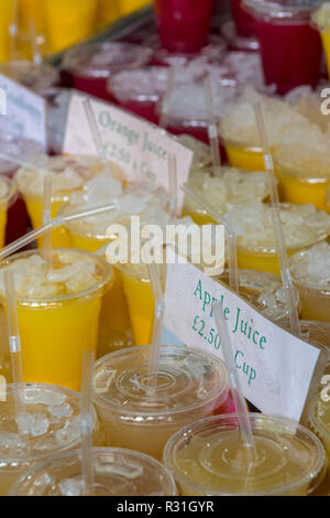 selection of handmade natural fruit juices with straws on sale at a juicing stall at a fruit and vegetable market in central london. Stock Photo