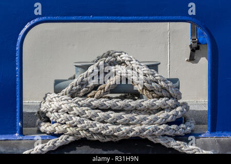 ships mooring or berthing bollards with a large rope wrapped around them to tie up a ship in harbour or docks Stock Photo