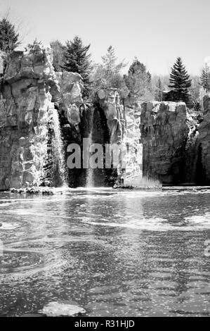 Water frozen in time over golden rocks. Stock Photo