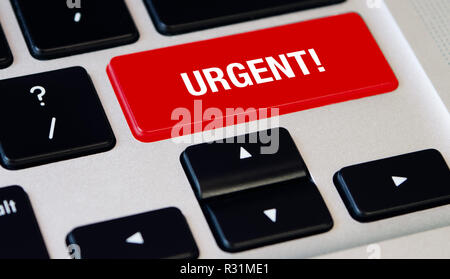 Computer notebook keyboard with Urgent red key, silver laptop with black keyboards Stock Photo