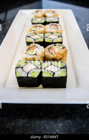 Mosaic sushi roll with cucumber and crab stick served on white plate Stock Photo